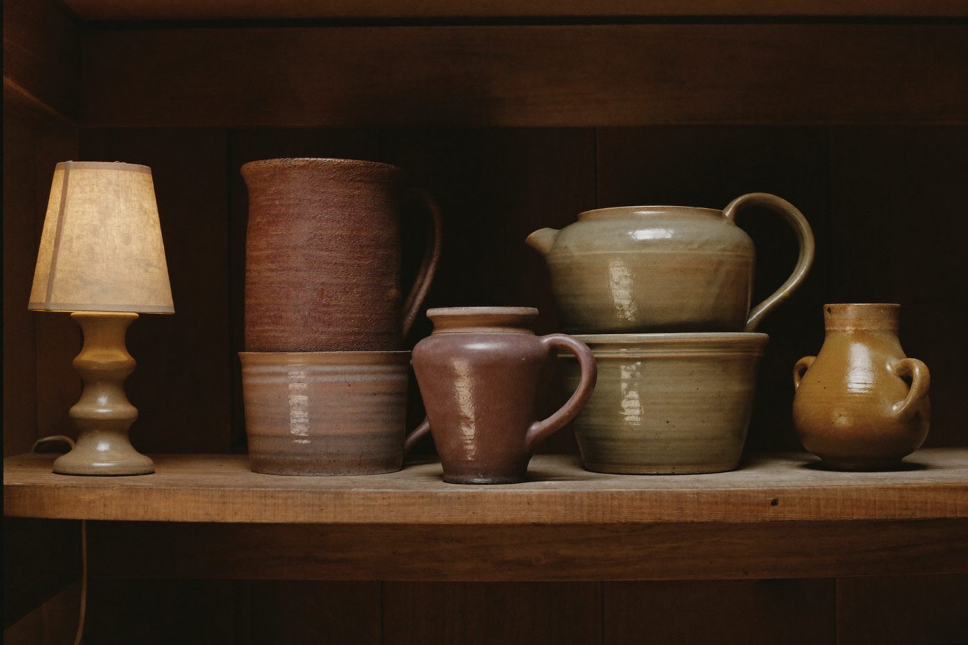 A shelf of glazed pots in warm light